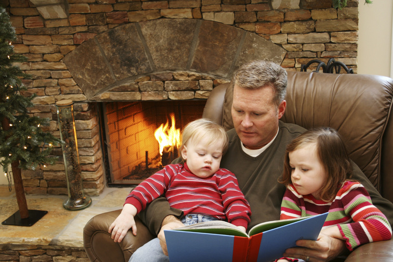 Dad and kids reading in front of fire